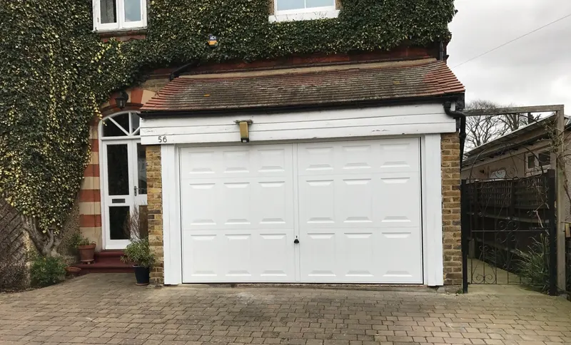 Garage door repair completed on a white panelled door in West London